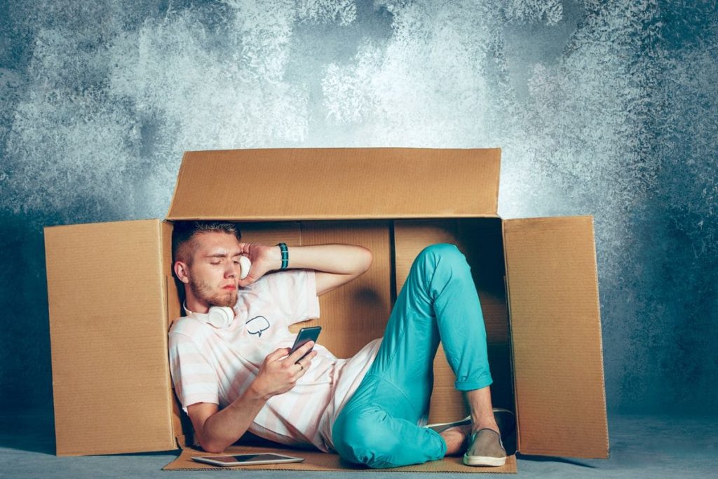 Introvert concept. Man sitting inside box