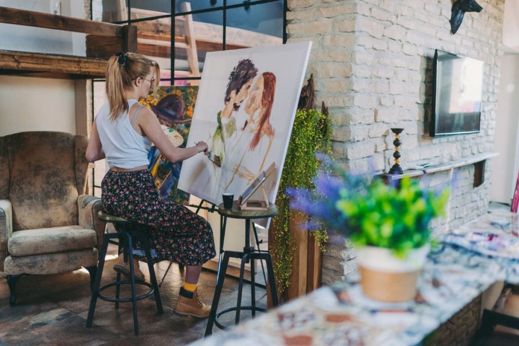 Home hobbies. Woman sitting on a bar chair, drawing a couple in love