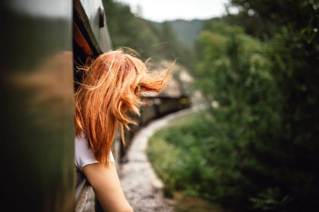 Adventure travel by train, woman traveling by train