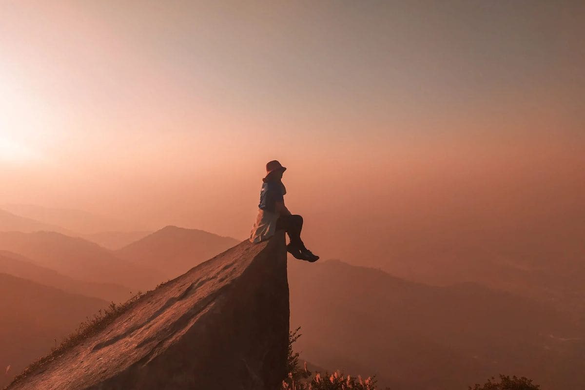 Alone Time, woman sitting on edge of a cliff