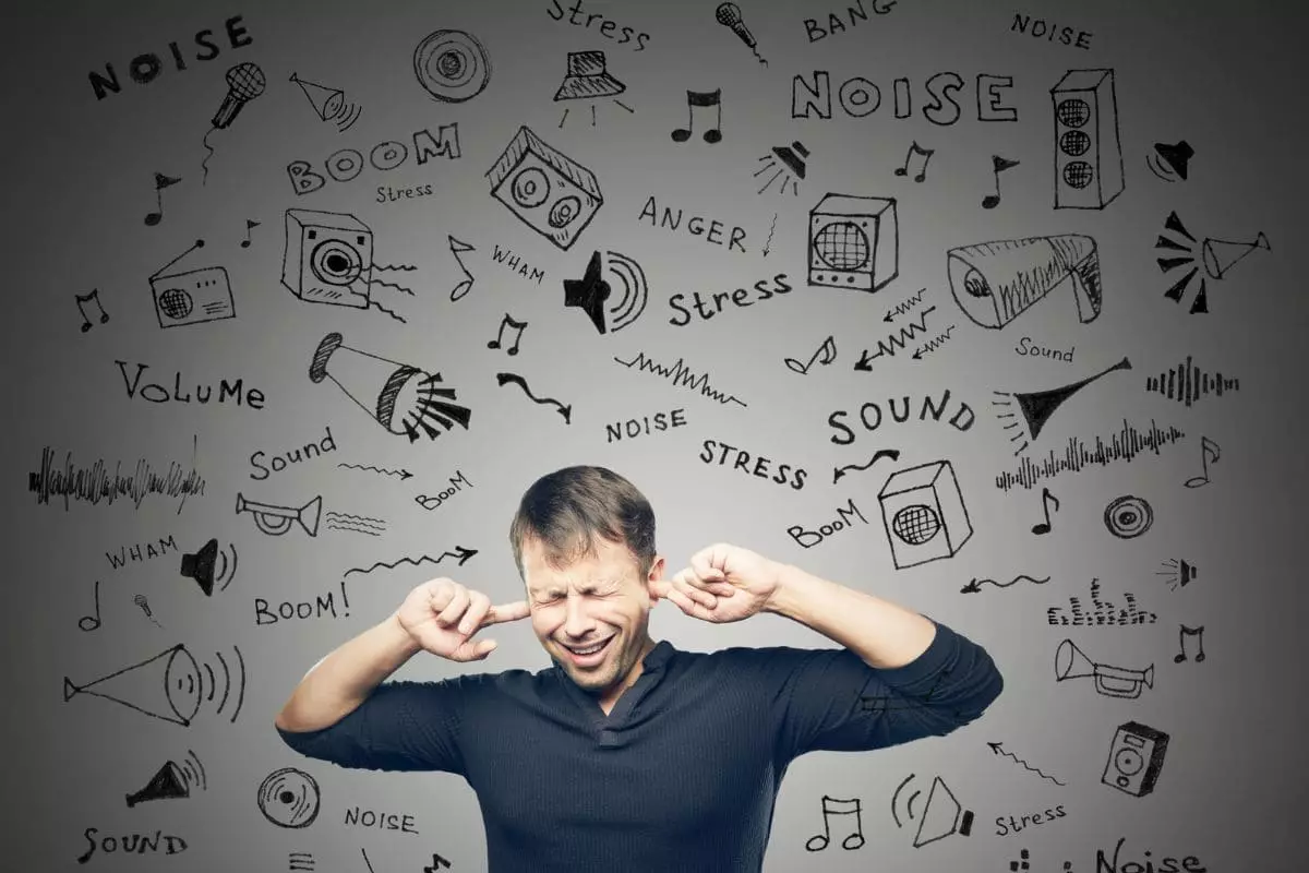 Man covering ears because of annoying noise