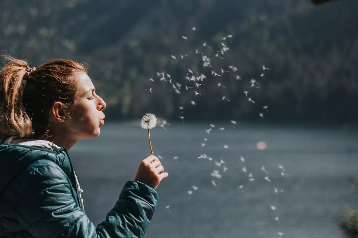 Woman blowing dandelion