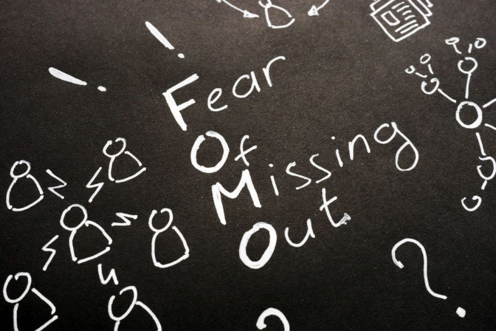 FOMO - Fear Of Missing Out sign on black sheet.