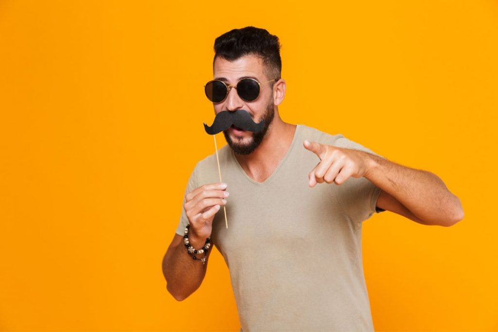 Portrait of a cheerful young casual man in sunglasses