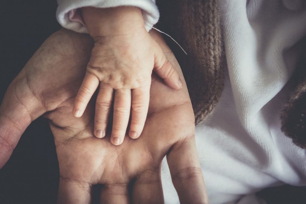 Child's hand resting on father's hand