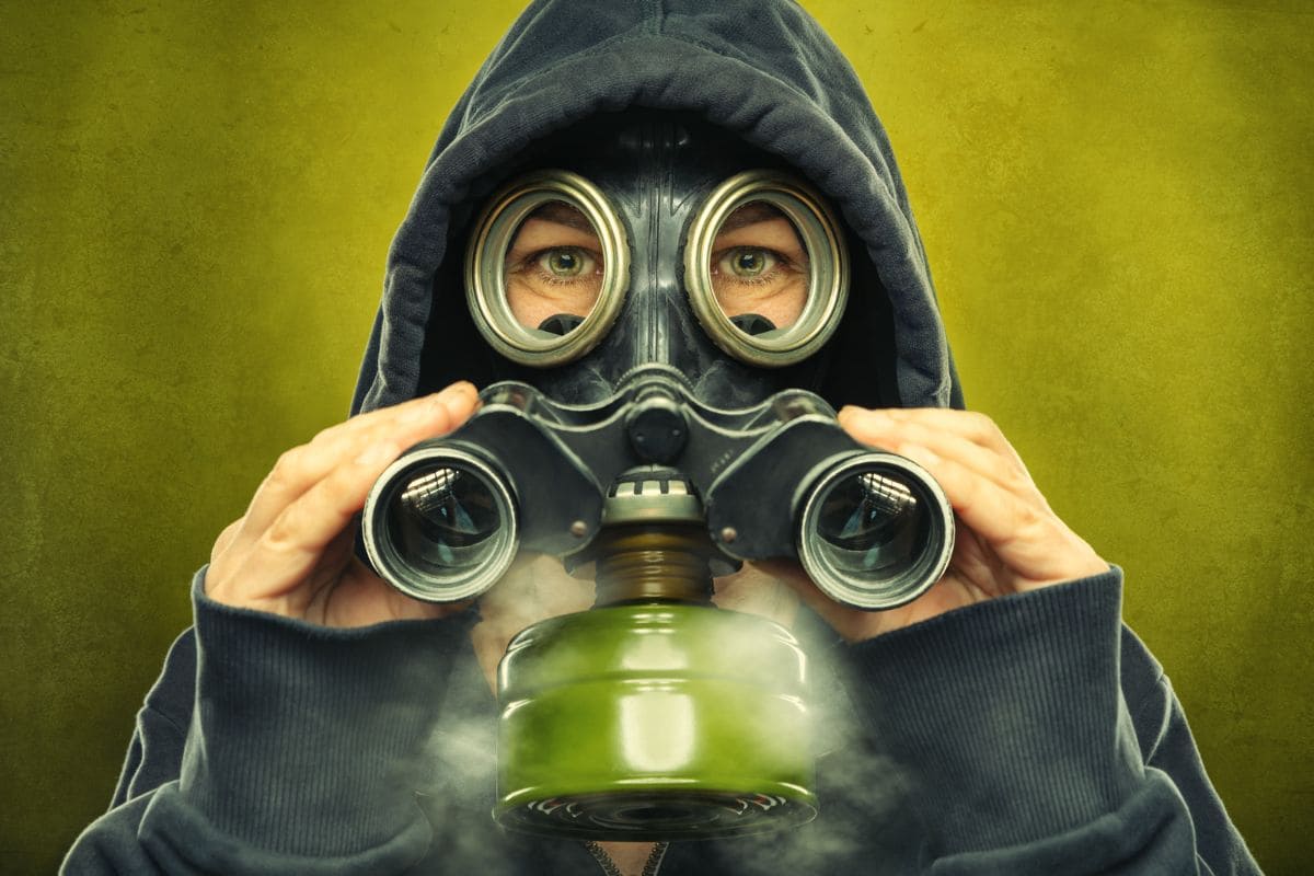Woman with hoodie wearing a gas mask