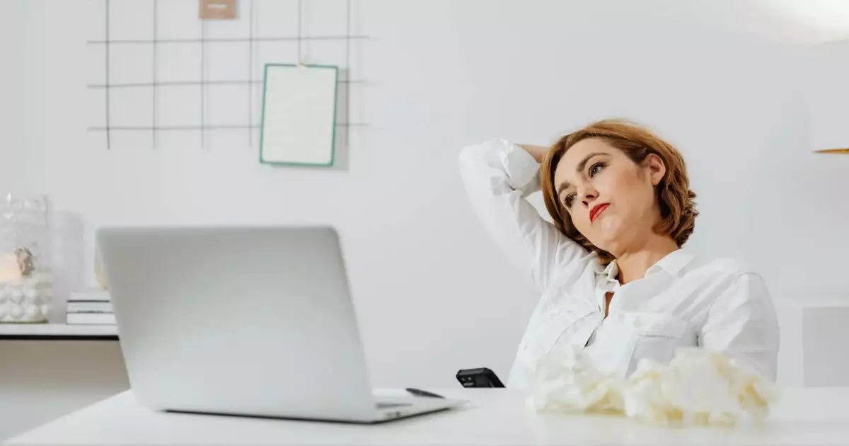 Woman in white long sleeves shirt sitting in front of a laptop