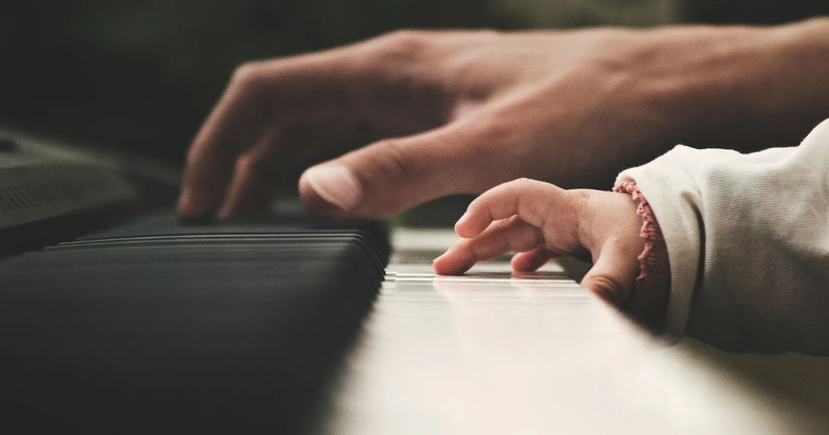 Kid and parent playing the piano