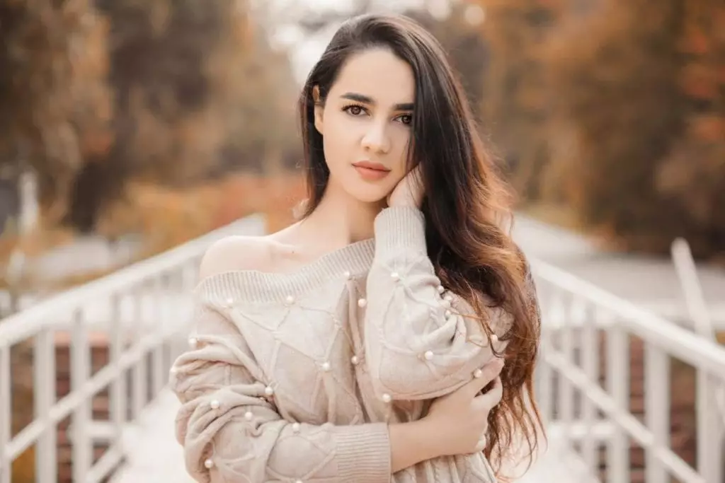 Beautiful woman looking direct in the camera, wearing a beige sweater